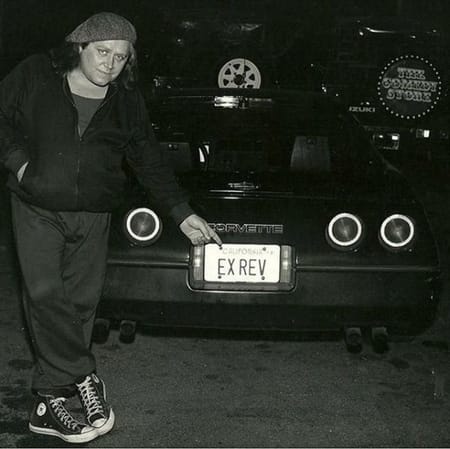 Sam Kinison showing his car in the photo